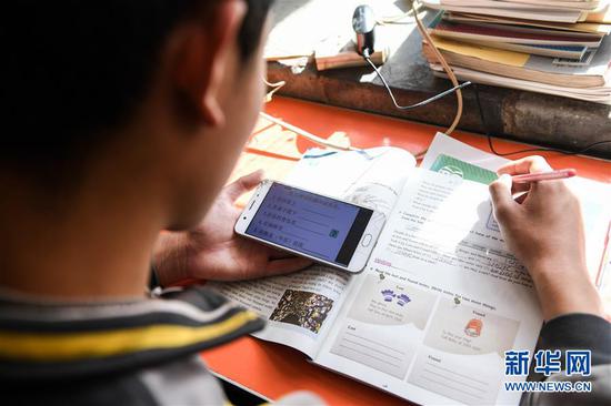  3月10日，內(nèi)蒙古準格爾旗龍口鎮(zhèn)紅樹梁村的初一學(xué)生劉進才在家中上網(wǎng)課。&nbsp;新華社記者 劉磊 攝