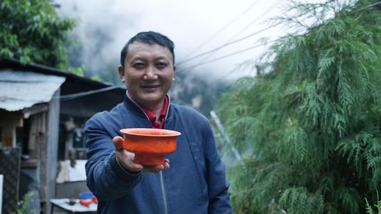  扎西巴珠展示他制作的木碗。新華網(wǎng) 旦增努布攝